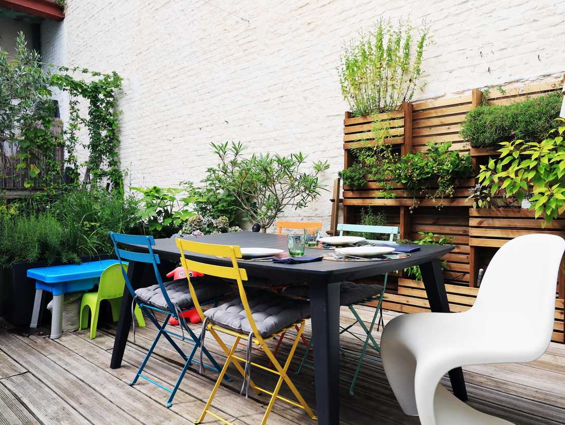 Terrasse en bois végétalisée avec table et chaises modernes